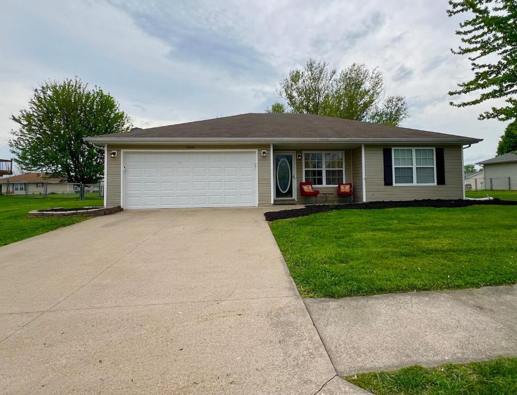a house with a garage and a driveway at Relax Enjoy Mid-Missouri with Fenced in Back Yard in Boonville
