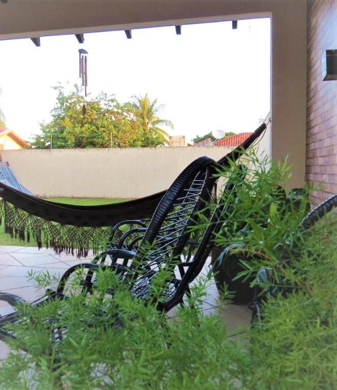 a hammock on a patio with plants at Hostel ElianeMS Quartos Privativos com Banheiro in Campo Grande