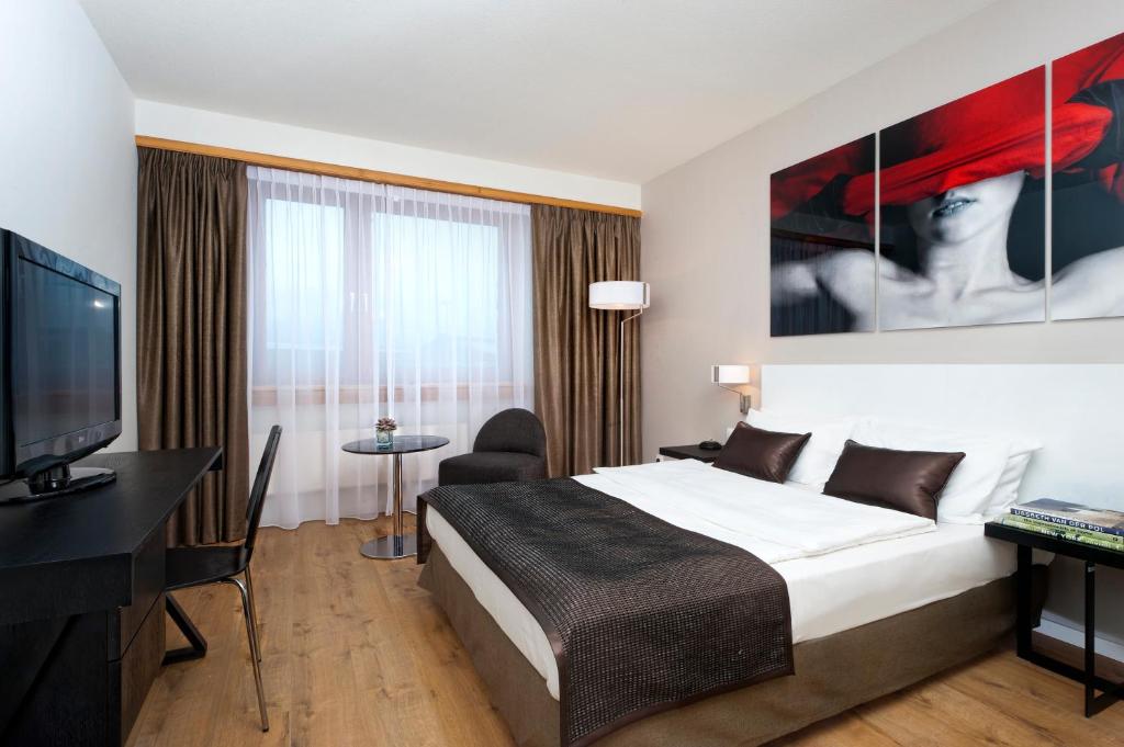 a hotel room with a bed and a flat screen tv at Wyndham Stuttgart Airport Messe in Stuttgart