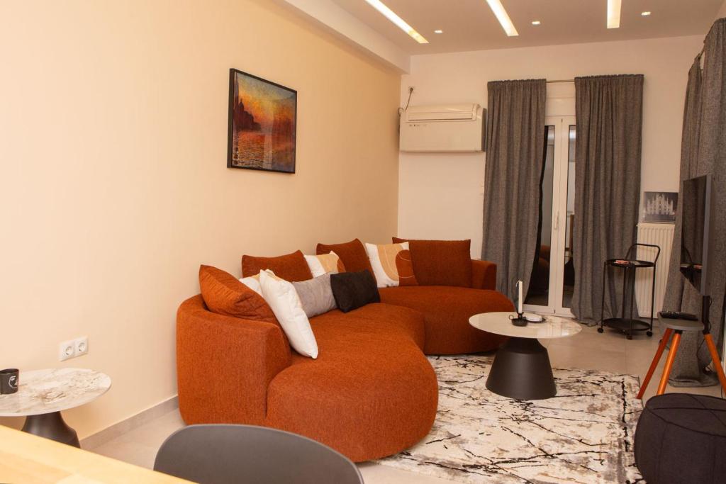 een woonkamer met een oranje bank en tafels bij Modern 1 bedroom apartment in Athene