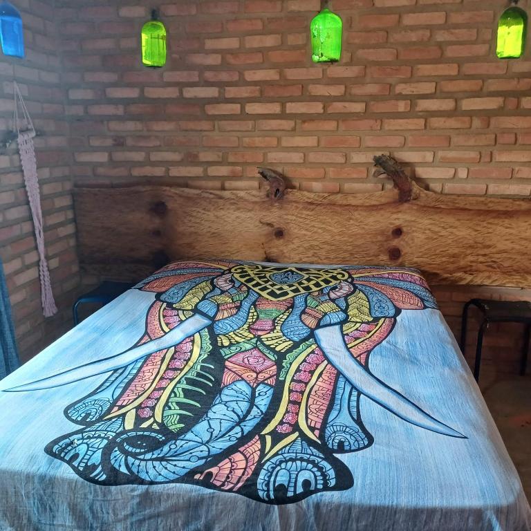 a bed with a painting of a octopus on it at Claudinha chalés in Conceição da Ibitipoca