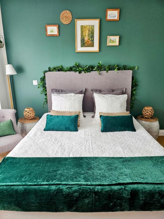 une chambre avec un grand lit aux murs verts dans l'établissement Studio Le Paradis Vert Aix-en-Provence, parking, piscine, à Aix-en-Provence