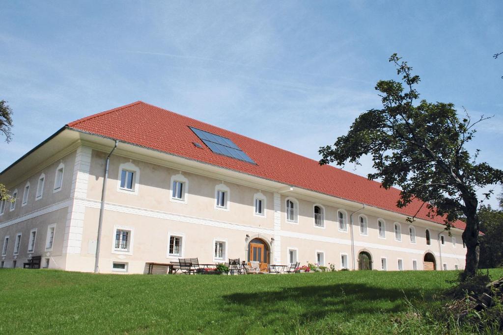 duży biały budynek z czerwonym dachem w obiekcie Waldbothgut w Linzu