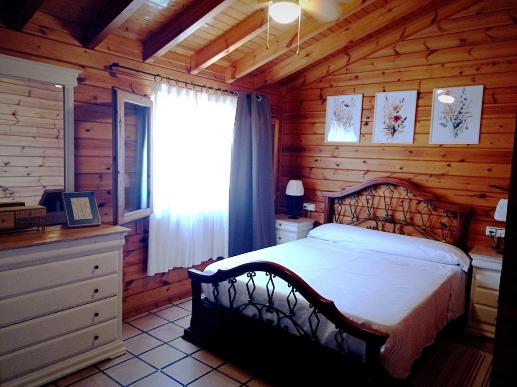 a bedroom with a bed in a log cabin at Chalet con piscina privada in Borriol