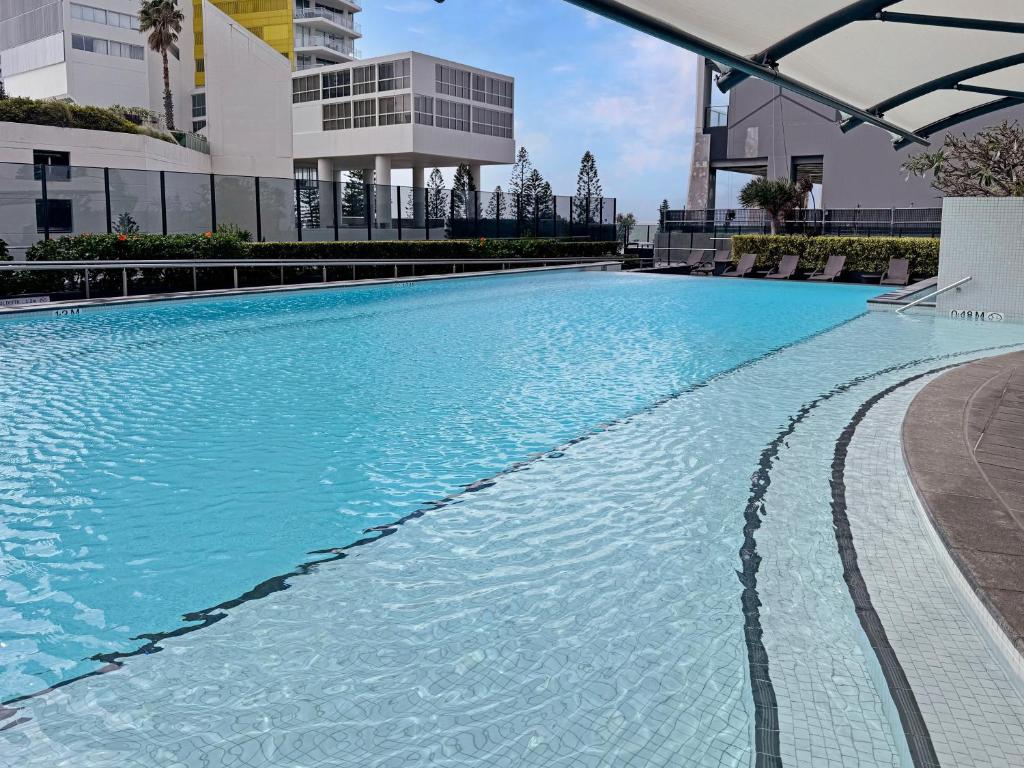 a large swimming pool with blue water in a building at Oracle 11th floor Tower 1 - GC Getaways in Gold Coast