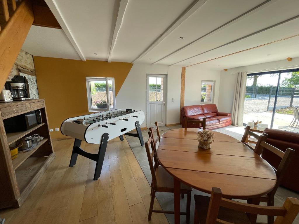 - un salon avec un piano et une table dans l'établissement Gîte chez Line & Mon, à Bournonville