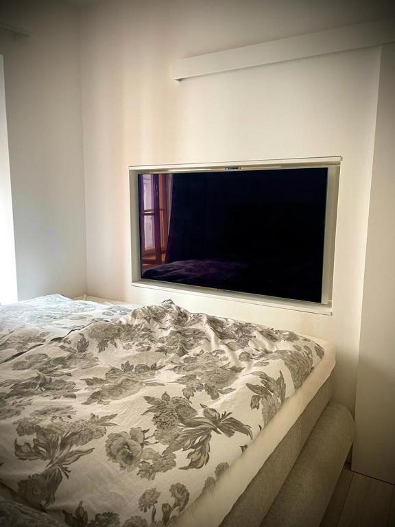 una camera da letto con una grande TV a schermo piatto a parete di MIMIs Lakeside Apartment - NEWLY RENOVATED a Gmunden