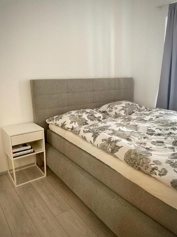 un letto in una camera da letto con comodino accanto ad esso di MIMIs Lakeside Apartment - NEWLY RENOVATED a Gmunden