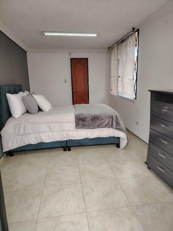 a bedroom with a bed and a dresser at hab chicamocha in Sogamoso