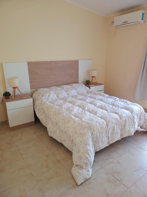 una camera da letto con un letto grande e due comodini di Once Reinas Departamentos a San Rafael