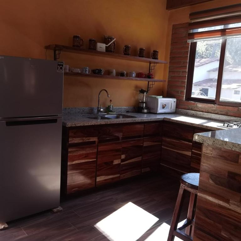 a kitchen with a refrigerator and a sink at Cabaña Arelys in Cedro