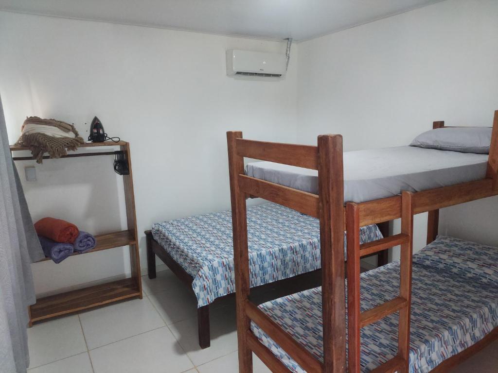 a small room with a bunk bed and a chair at Maravilha do Patacho in Pôrto de Pedras
