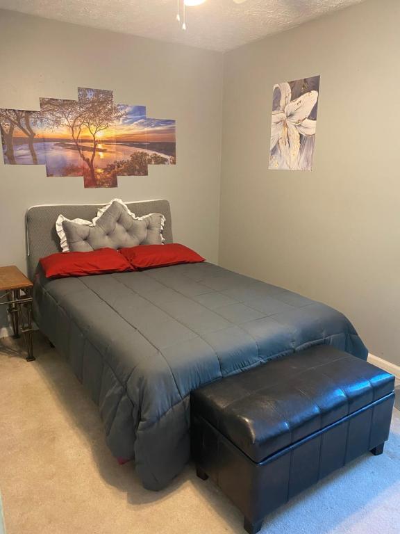 un dormitorio con una cama con un puf de cuero en PaulKTA, en Nashville