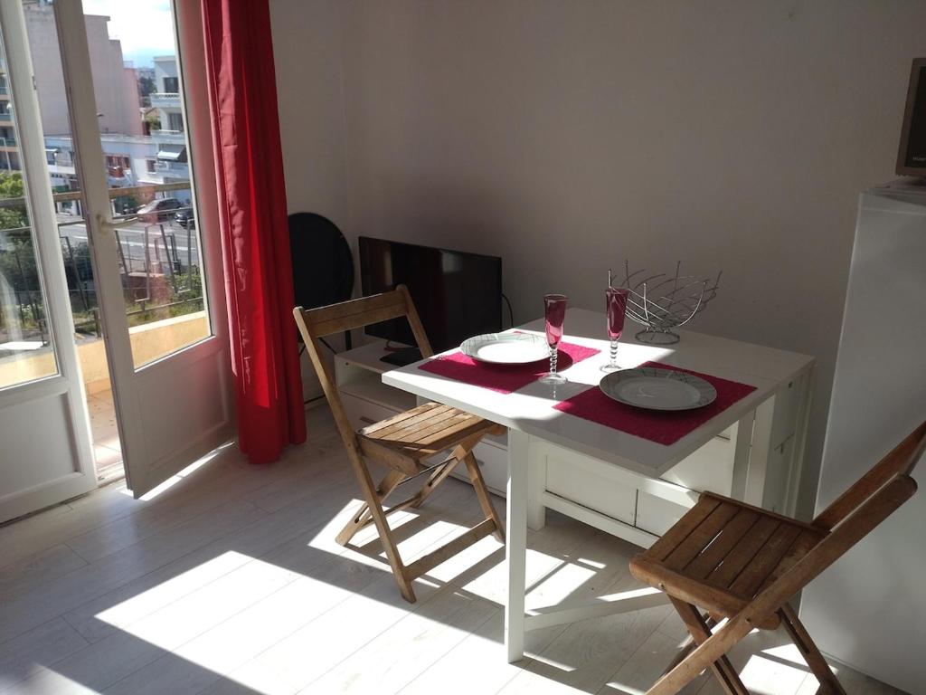 une table blanche avec deux assiettes et deux verres dessus dans l'établissement Les Floralies, à Juan-les-Pins