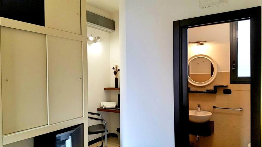 un bagno con lavandino, water e specchio di B&B Casanova a Minervino di Lecce