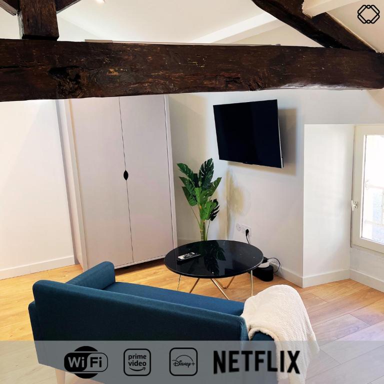 un salon avec un canapé bleu et une table dans l'établissement Studio Nid Urbain, à Angoulême