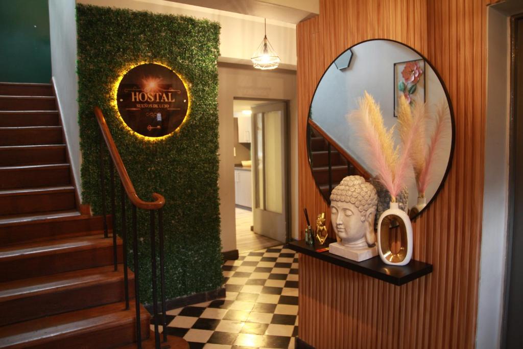 a hallway with a staircase and a mirror and a statue at Hostal Sueños De Lujo in Talca