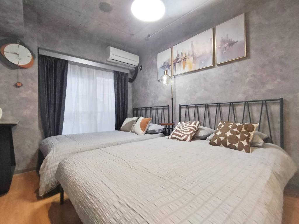 a bedroom with two beds and a window at PA Shinjuku St a-9mins -Higashishinjuku subway-5mins-新宿-步行伊势丹8分-MAX4p in Tokyo