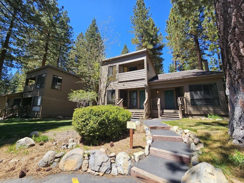 a house in the woods with a path leading to it at Pinenut Place home in Incline Village