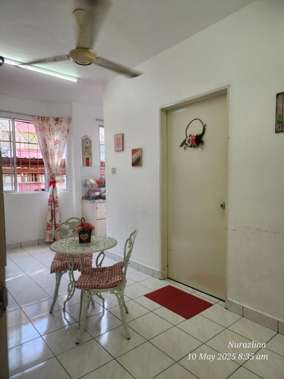 a dining room with a table and chairs and a door at Dihome Ariel Twin Bed in Donggongon