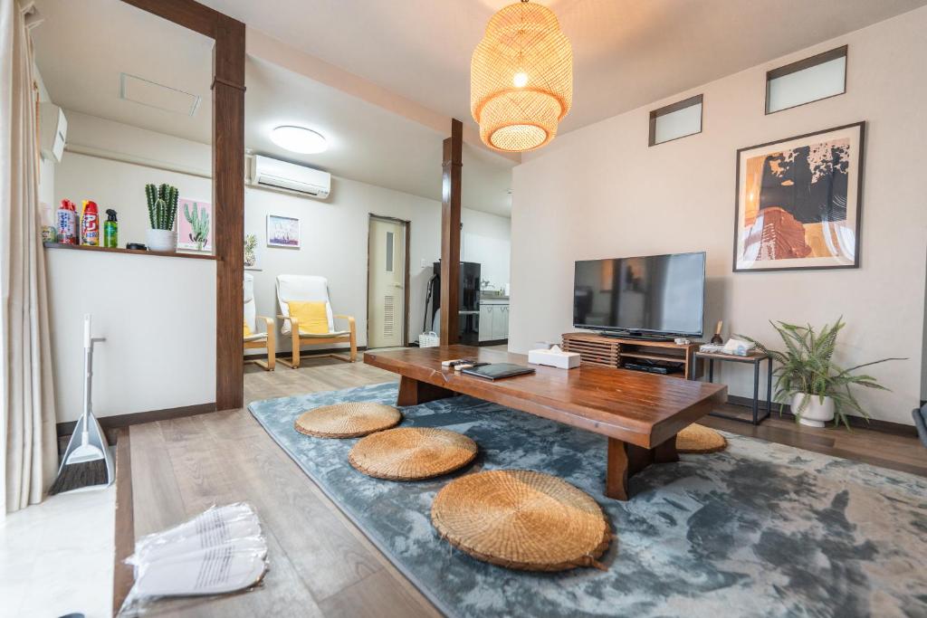 Una sala de estar con una mesa y un televisor. en 夏風-なつバル-, en Isla Miyako