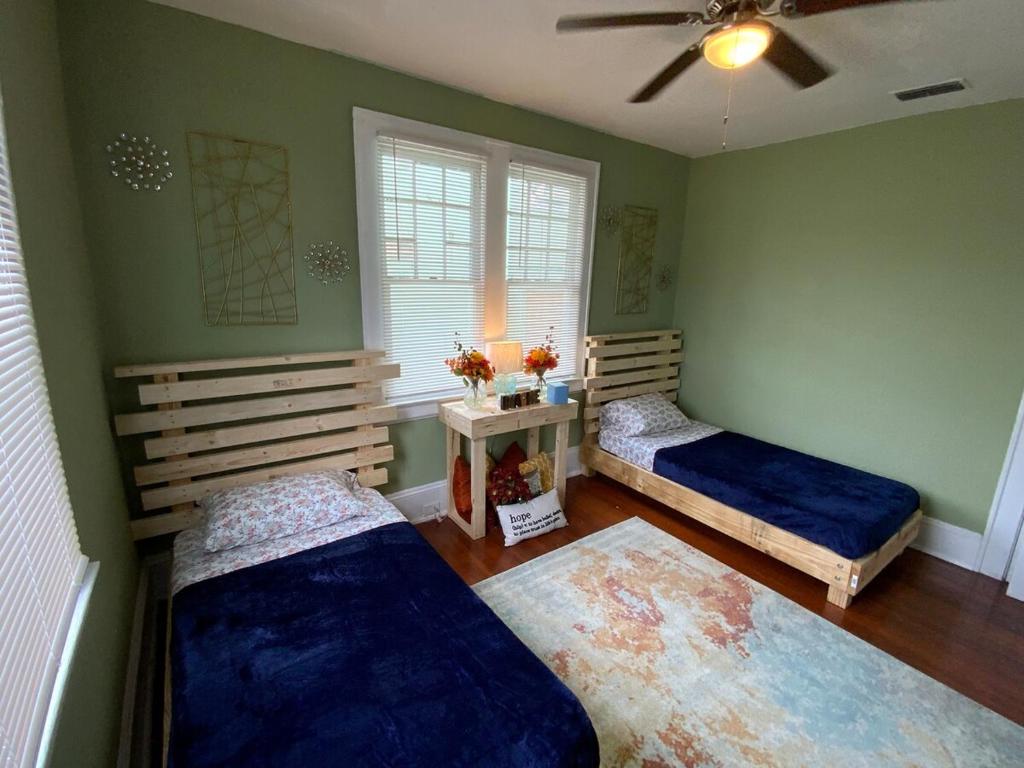 twee bedden in een kamer met groene muren bij Cozy Cottage in Jacksonville