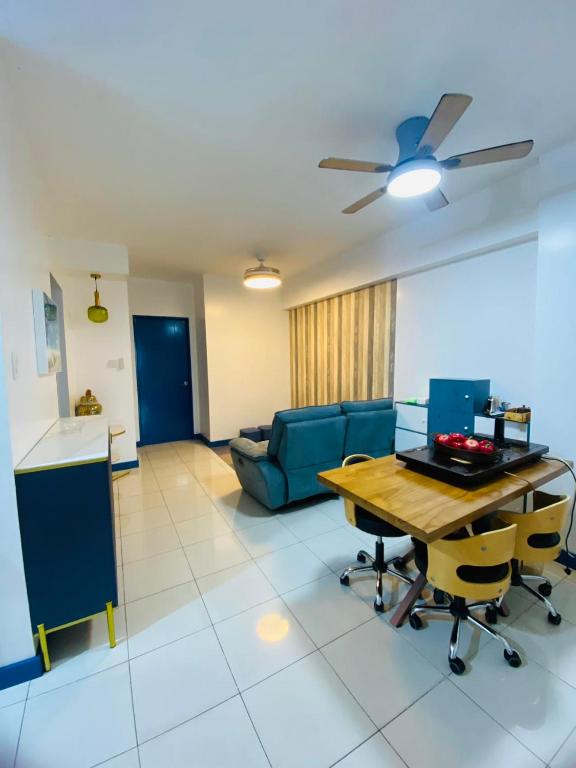 a living room with a table and a blue couch at Torre De Manila taft Tan38 in Manila