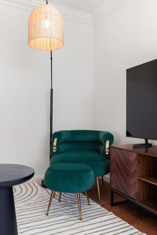 a living room with a green chair and a tv at Relaxing 2-Bedroom Oasis in Pacifica in Pacifica