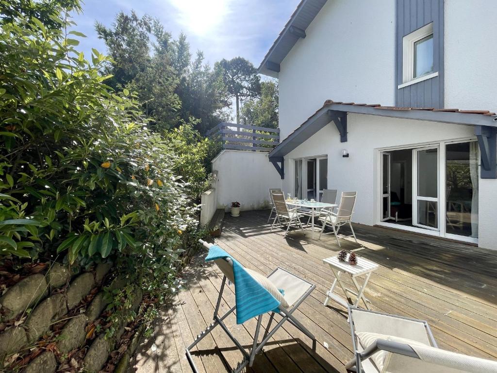 une terrasse en bois avec des chaises et une table. dans l'établissement T2 cabine avec grande terrasse sans vis à vis, parking privatif, à 100m des plages - FR-1-420-47, à Pyla-sur-Mer