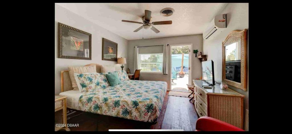 een woonkamer met een bed en een plafondventilator bij Blue River Breeze Guest Suite in Daytona Beach