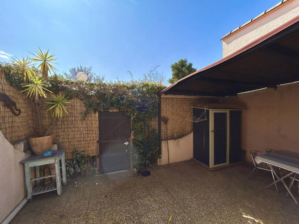 - un bâtiment en briques avec une porte et une terrasse dans l'établissement Pavillon avec mezzanine, terrasse ensoleillée, WIFI et parking à Argelès-sur-Mer - FR-1-388-240, à Argelès-sur-Mer