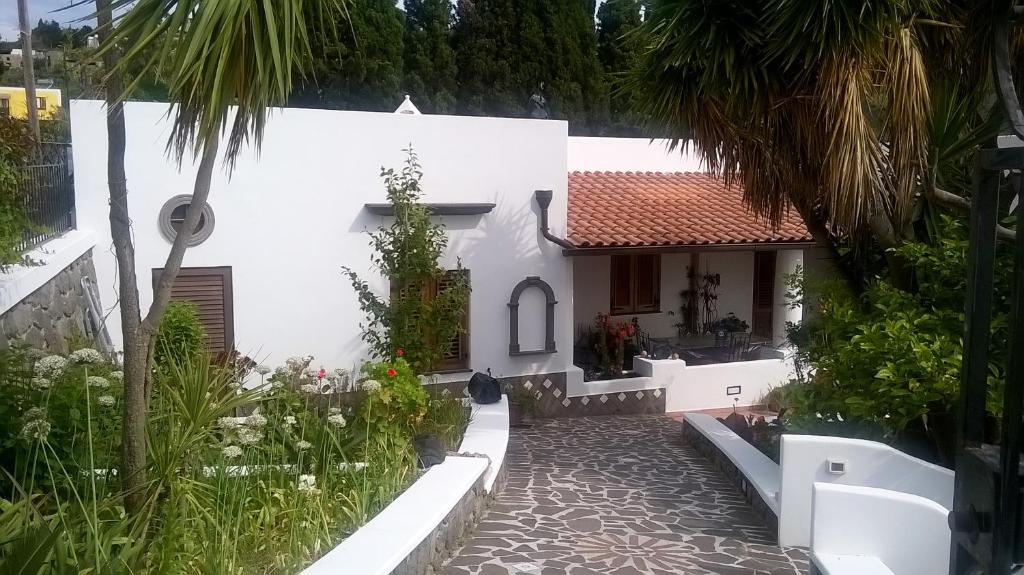 a white house with a garden and a courtyard at Casa Vacanze "Villa Angelina" in Lipari