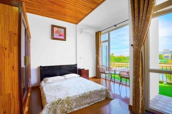 une chambre avec un lit et une grande fenêtre dans l'établissement T'Homestay garden villa, à Thôn Lại Thê