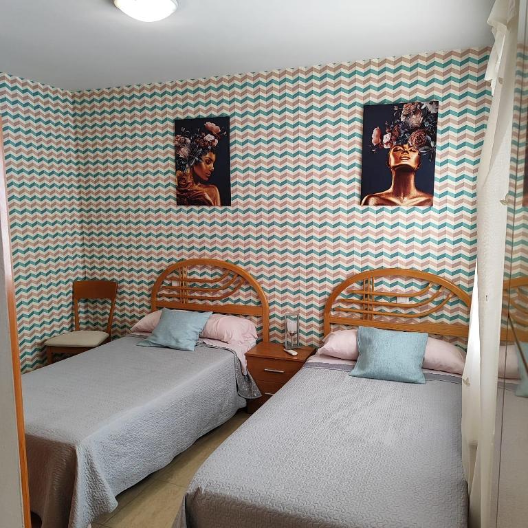 a room with two beds and a wall with pictures at Jesús Del Perdón in Manzanares