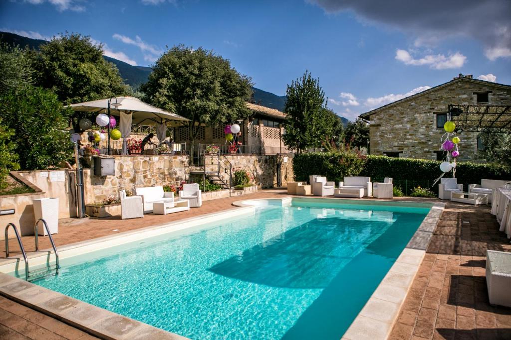 una piscina con sillas y una casa en Villa Rosy, en Asís