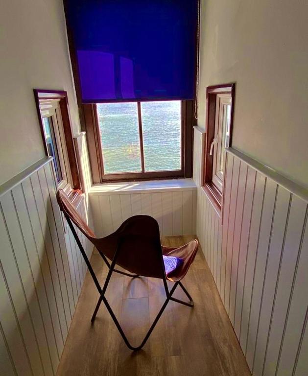 a chair sitting in a room with a window at No: 1 The Esplanade Guest Accommodation. in Tenby