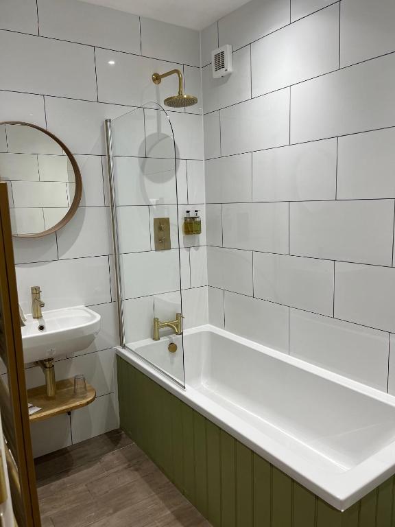 a bathroom with a bath tub and a sink at No: 1 The Esplanade Guest Accommodation. in Tenby