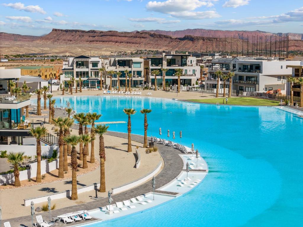 een groot zwembad met palmbomen en gebouwen bij Lagoon Desert Retreat condo in St. George