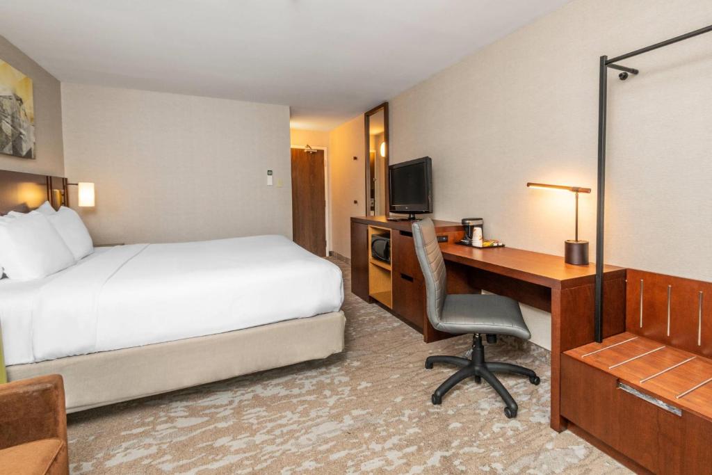 a hotel room with a bed and a desk with a computer at Comfort Inn in Ottawa
