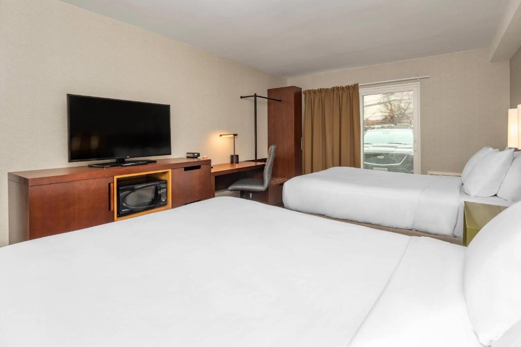 a hotel room with two beds and a flat screen tv at Comfort Inn in Ottawa
