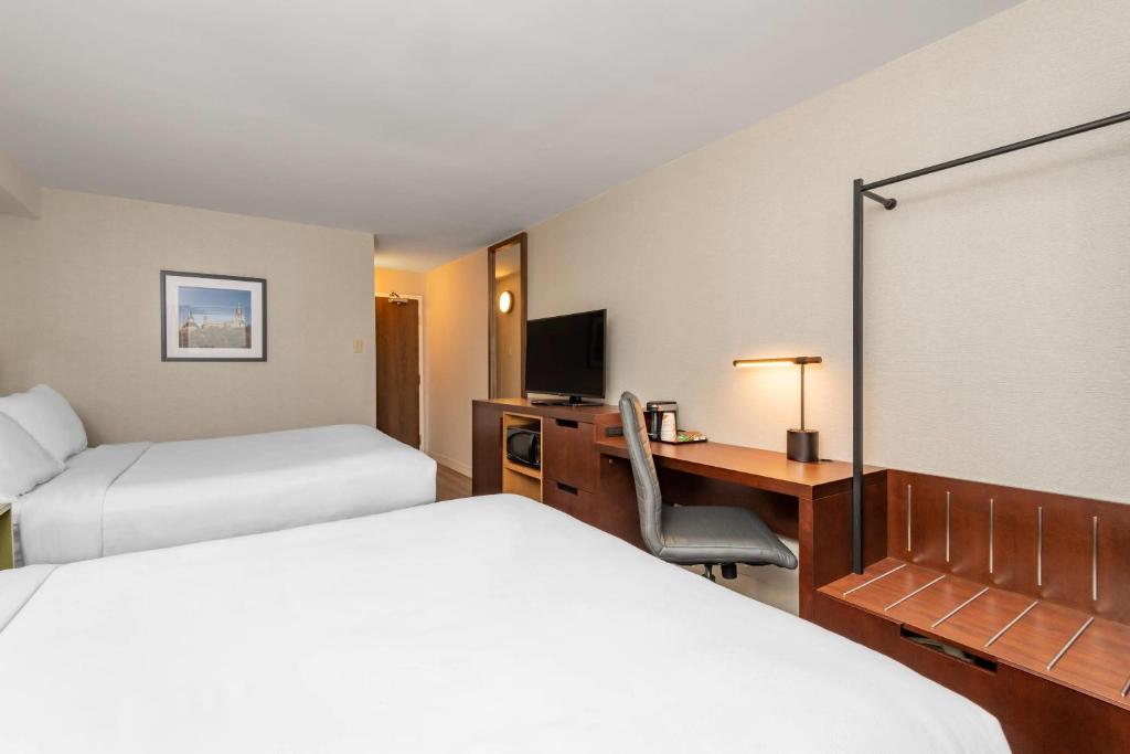 a hotel room with two beds and a desk at Comfort Inn in Ottawa