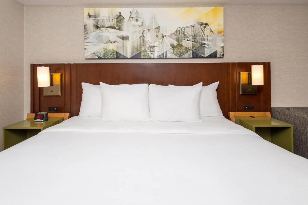 a bed with white pillows in a hotel room at Comfort Inn in Ottawa