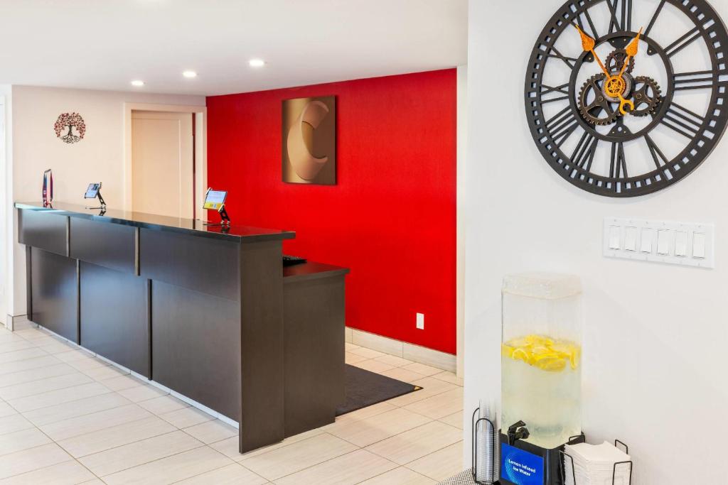 a red wall with a large clock on a wall at Comfort Inn in Charlottetown