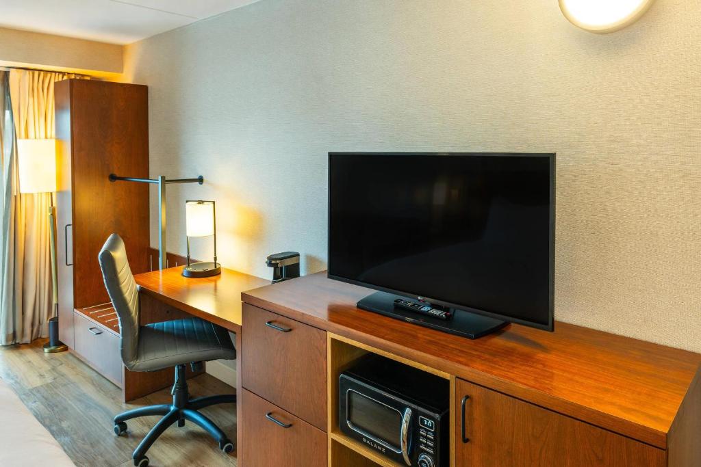 a hotel room with a desk and a television on a wooden cabinet at Comfort Inn in Charlottetown