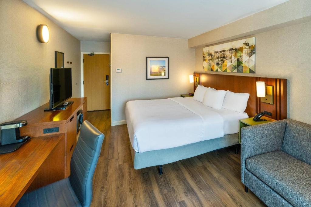 a hotel room with a large bed and a chair at Comfort Inn in Charlottetown