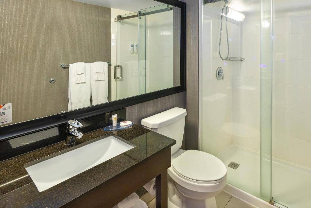 a bathroom with a toilet and a sink and a shower at Comfort Inn in Charlottetown