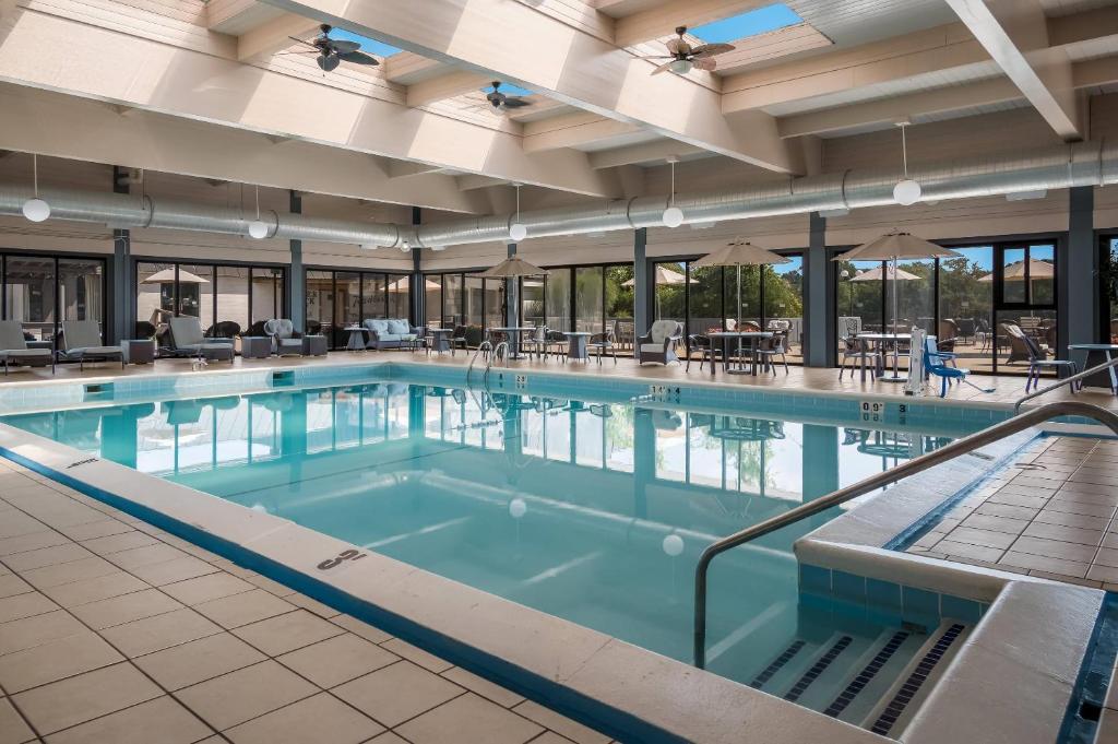 a pool in a hotel with tables and chairs at Radisson Hotel Grand Rapids Riverfront in Grand Rapids