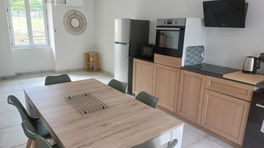 a kitchen with a wooden table and a kitchen with a table and chairs at chez Marie et Xav in Frasne-les-Meulières