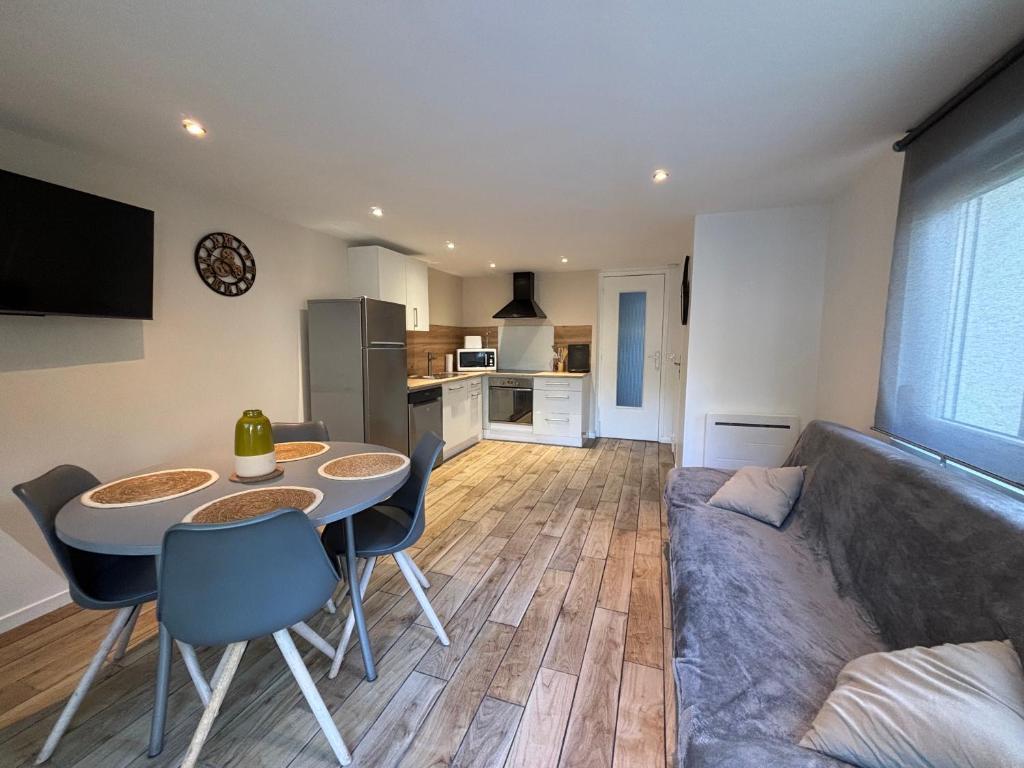 un salon avec un canapé, une table et des chaises dans l'établissement Gîte Mer et Campagne, à Saint-Martin-Plage