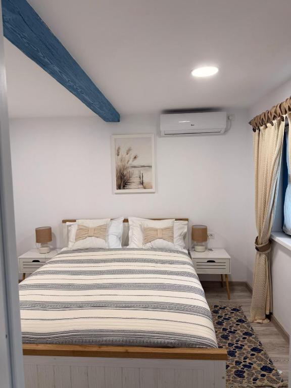 a bedroom with a bed and two night stands at Casa lui Matei Murighiol#2 in Murighiol